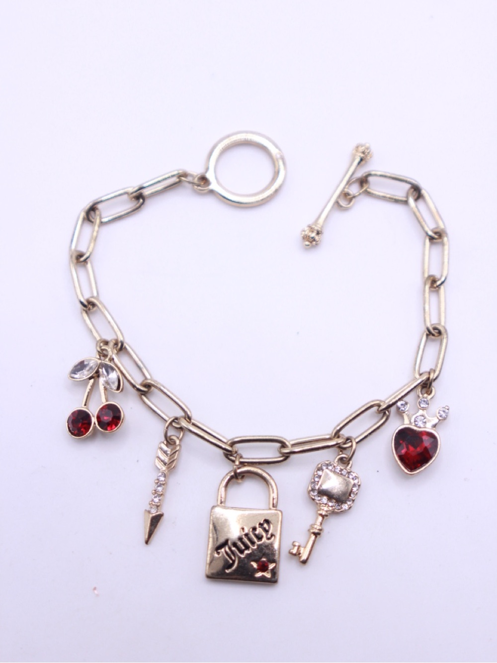 Juicy Couture Gold Charm Bracelet with Red Crystal Charms